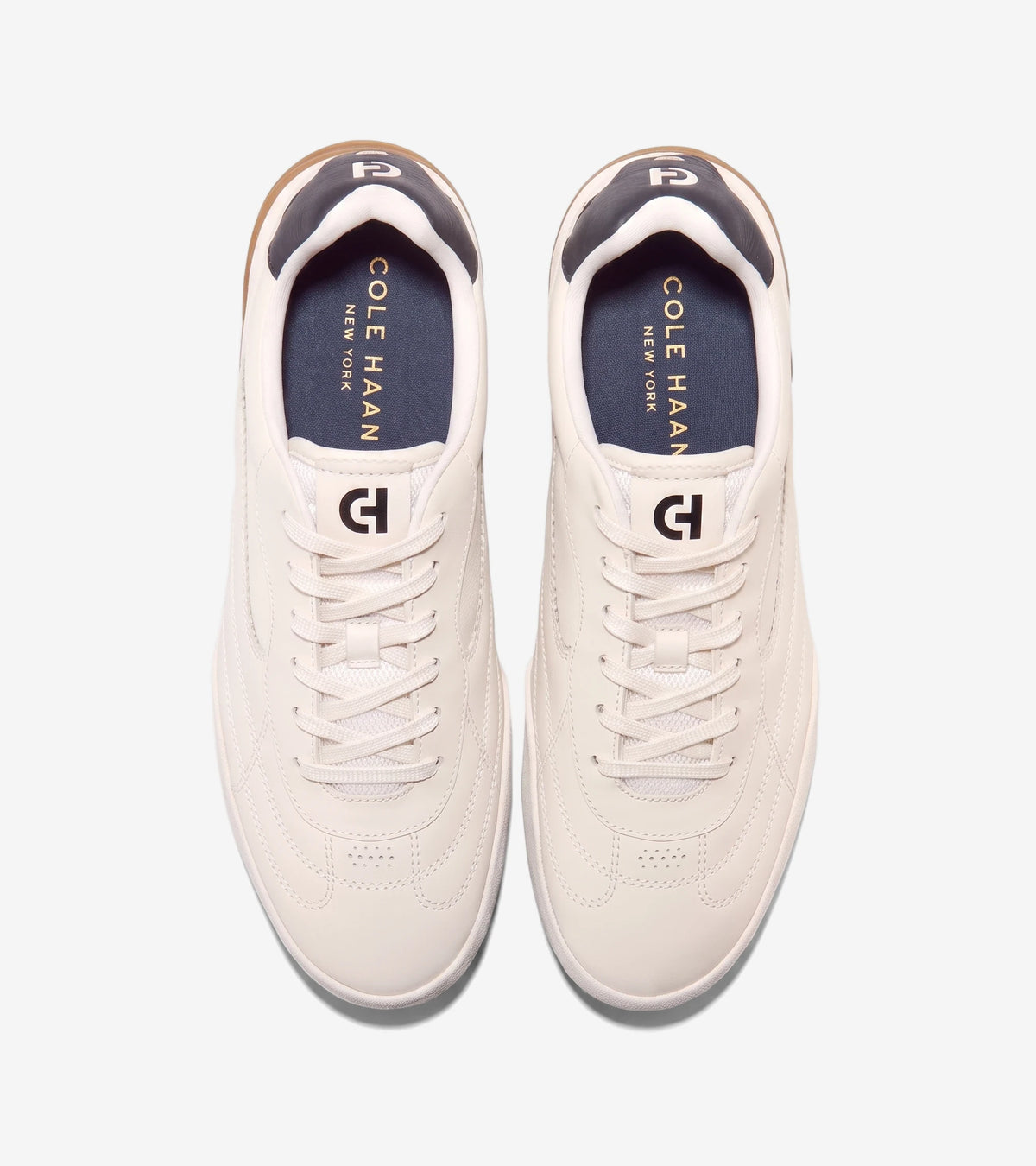 Pair of Cole Haan Grandpro Turf 2.0 sneakers in ivory and silver birch, crafted from leather, shown from an overhead