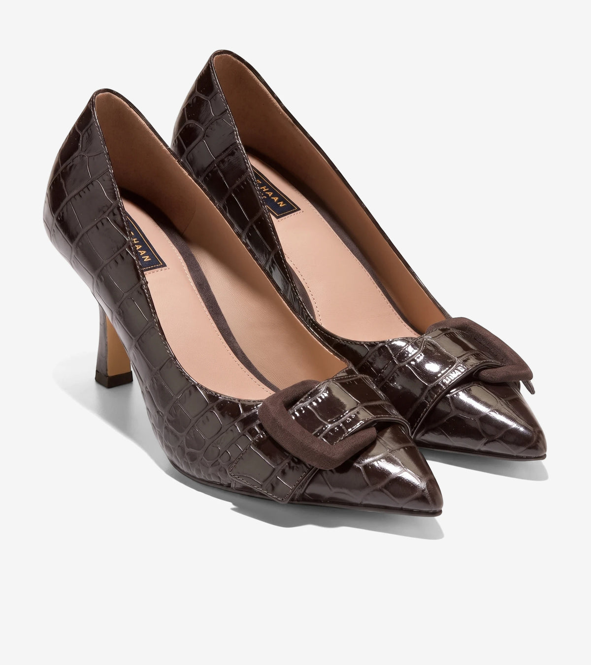 Pair of dark chocolate brown alligator print patent leather pumps featuring a rectangular suede buckle, side view, on a