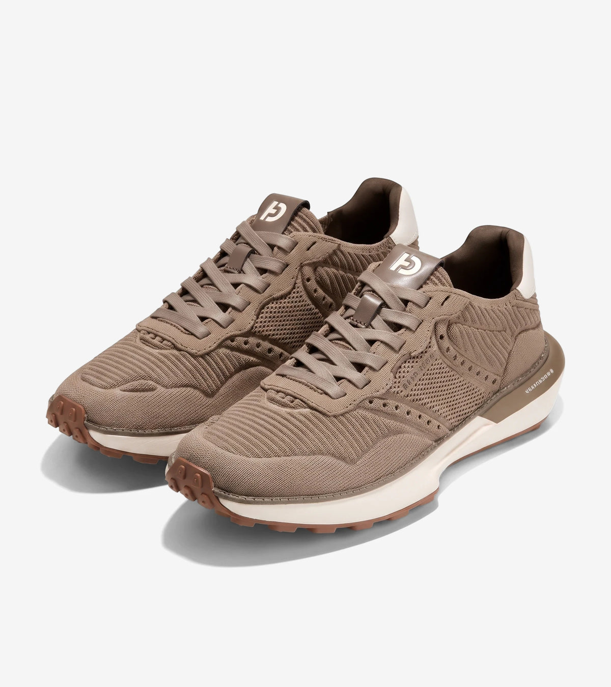 A pair of men's GrandPrø Ashland Stitchlite sneakers in a light brown knit, with white midsoles and textured brown outsoles.