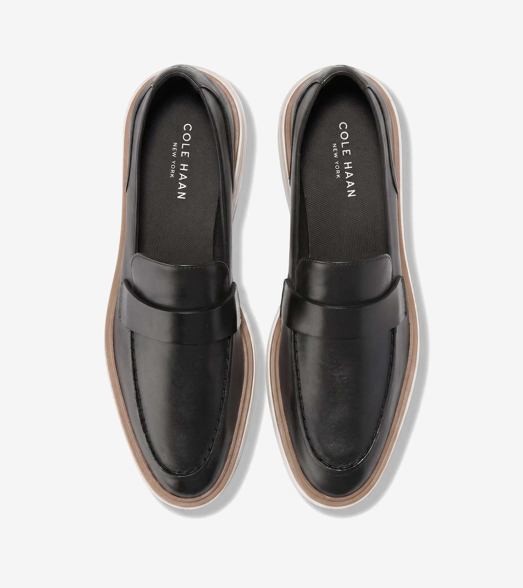 Women's ØriginalGrand CitySpectre loafers in black leather with visible white and brown platform soles, viewed from above.